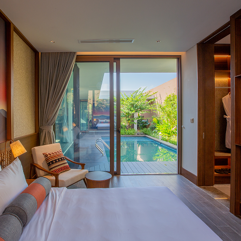 modern hotel room interior with a private pool view through floor-to-ceiling glass doors